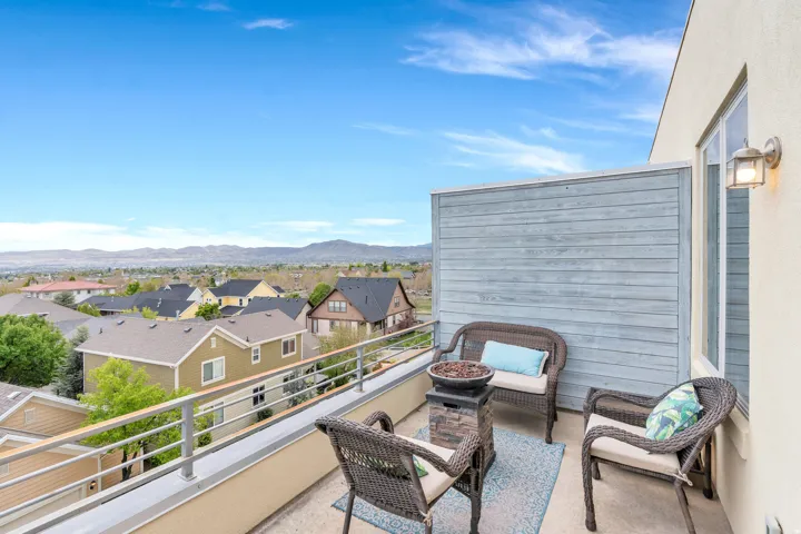 Expansive rooftop terrace featuring a concrete surface, metal railings, and a privacy wall with horizontal siding