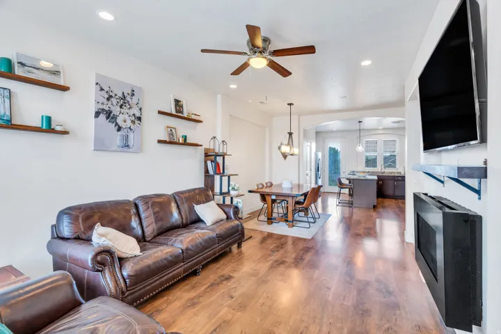Open-concept living area featuring wood-finish flooring, recessed lighting, and a ceiling fan