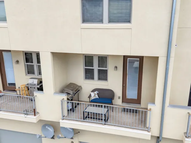 Two private recessed balconies featuring concrete flooring and metal railings