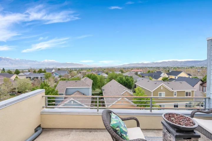 Rooftop deck featuring a metal railing, concrete surface, and stucco exterior walls