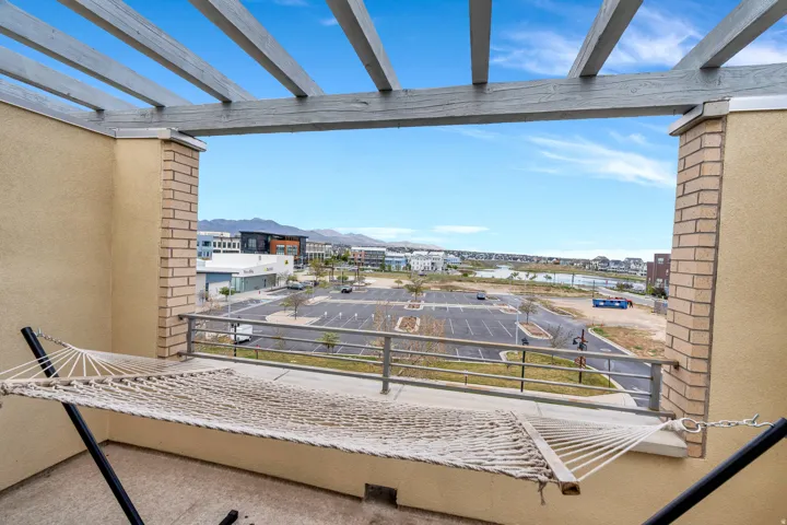 Expansive balcony featuring a wooden pergola and brick columns
