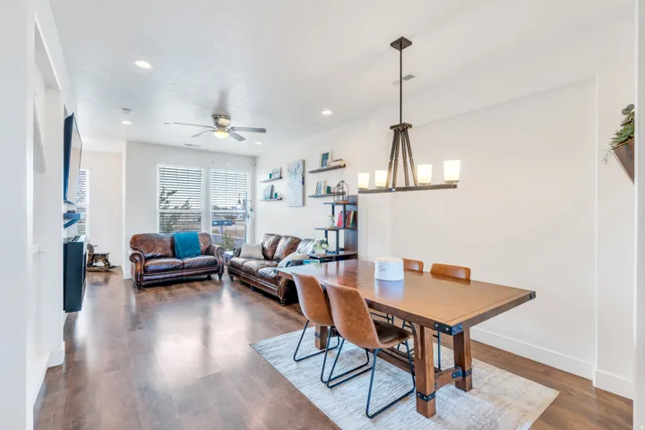 Open-concept living and dining area featuring wood-finish flooring, recessed lighting, and a modern ceiling fan