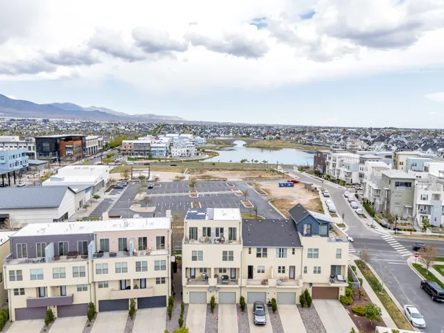 Modern multi-level townhome with an integrated garage, private balcony, and rooftop patio