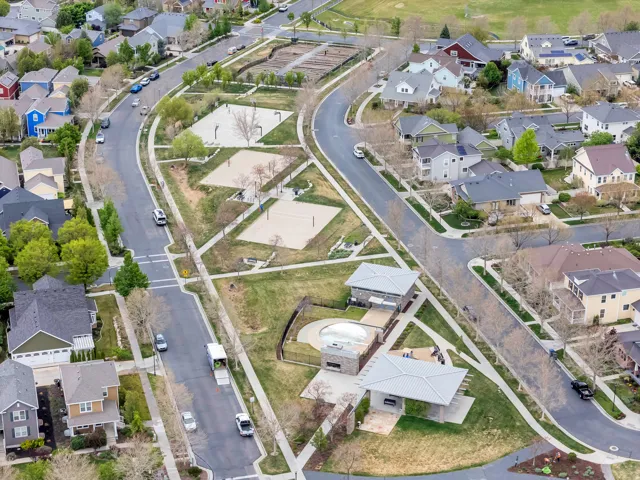 Aerial representation of a residential area featuring multiple single-family homes, paved streets, and a recreational zone
