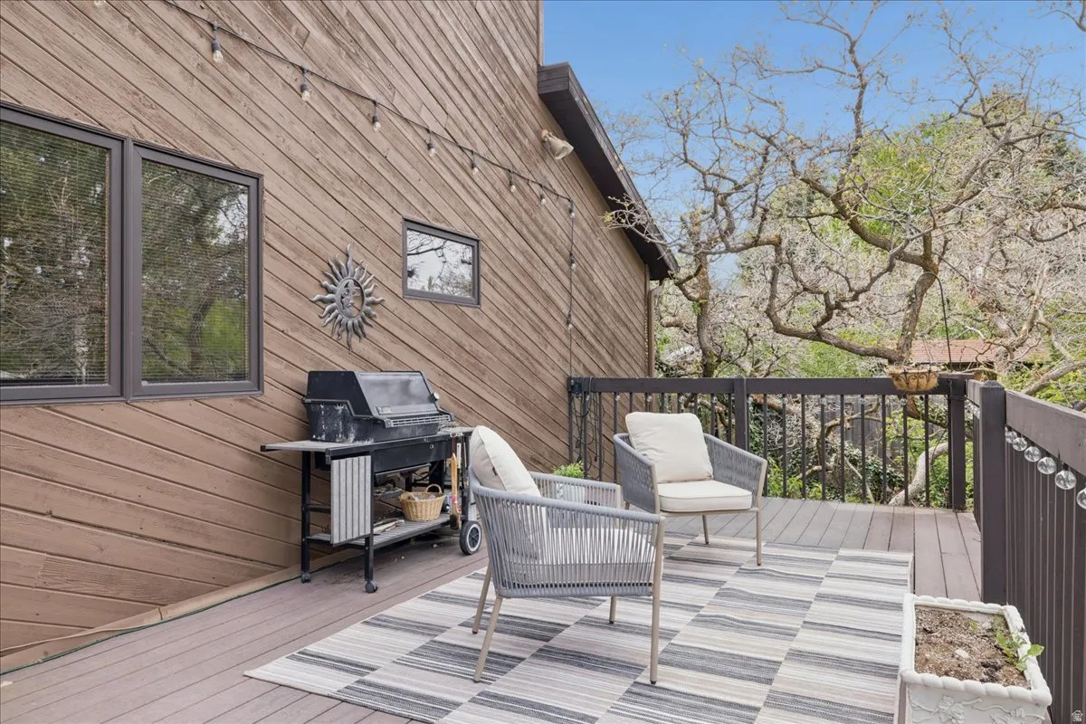 Expansive outdoor deck featuring wood-finish flooring and a dark wood railing system