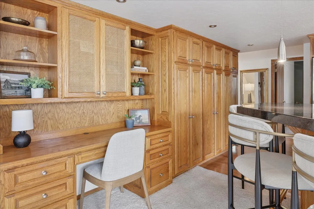 Integrated wood-finish desk with shelving and cane-front cabinetry