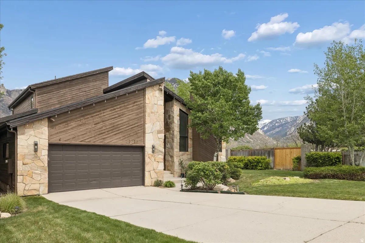 Contemporary sloped roofline exterior with natural stone and wood-finish siding