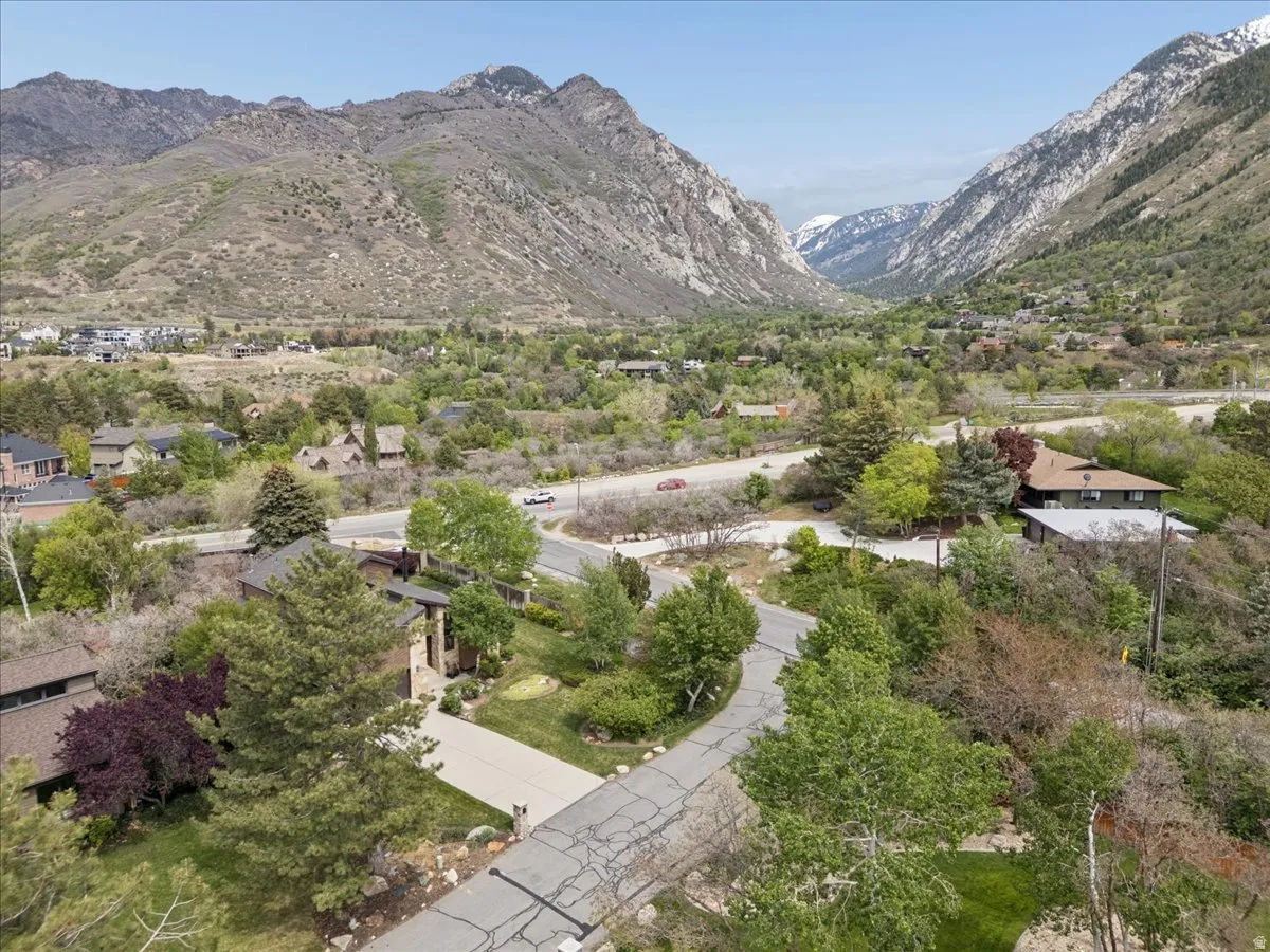Lush, verdant valley setting featuring distant snow-capped mountains. View of Little Cottonwood Canyon.