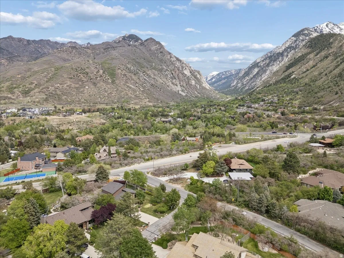 Expansive mountain valley landscape featuring residential properties nestled among mature trees. View of Little Cottonwood Canyon.