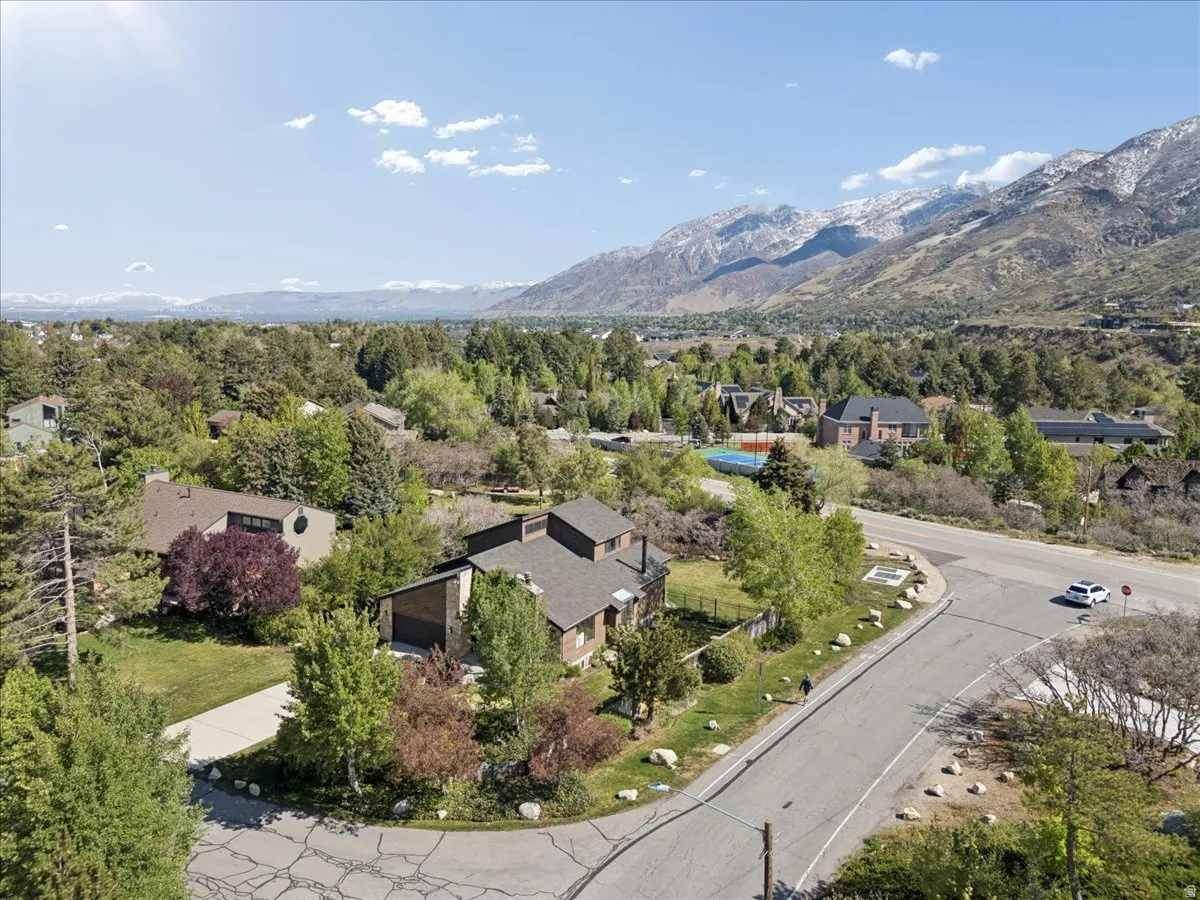Aerial perspective highlighting a residential property with a multi-level roofline and mature landscaping