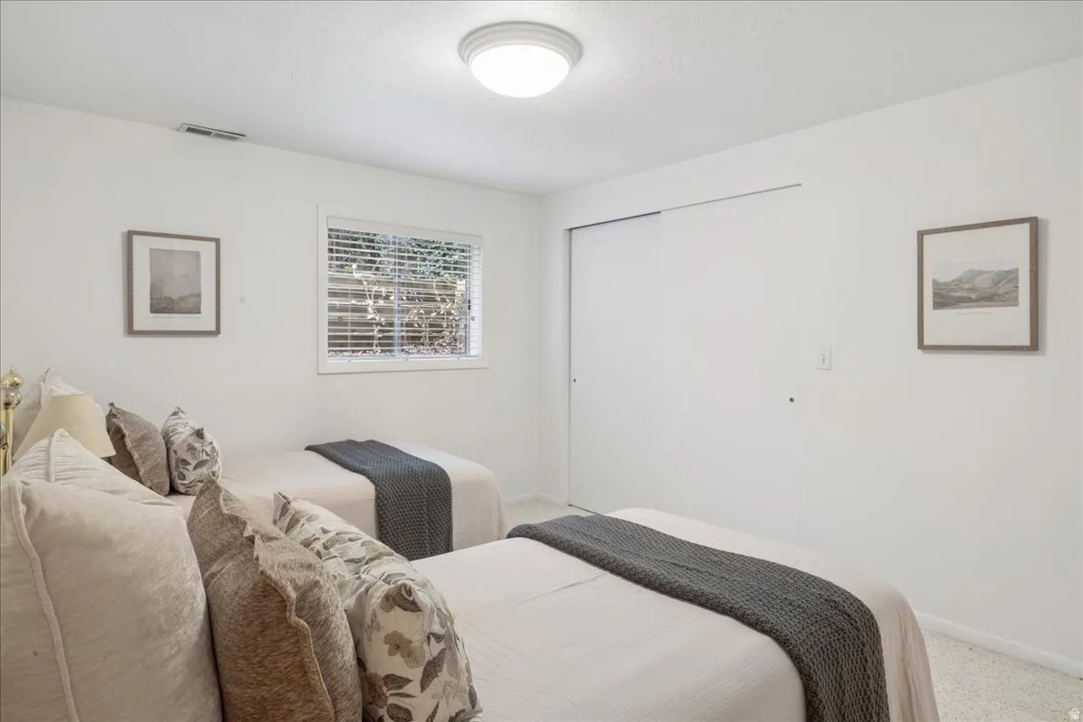 Bright room featuring a window with horizontal blinds, a flush-mount ceiling light, and wall-to-wall carpeting