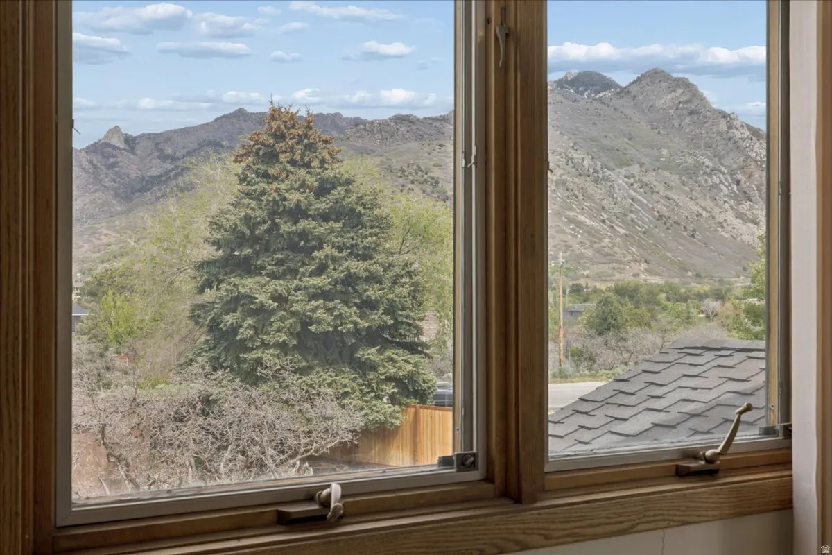 Wood-framed casement windows with brass hardware, offering expansive mountain scenery