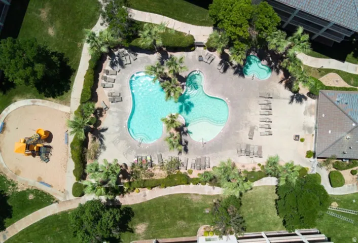 Expansive outdoor amenity area featuring a freeform swimming pool, integrated spa, and surrounding lounge seating