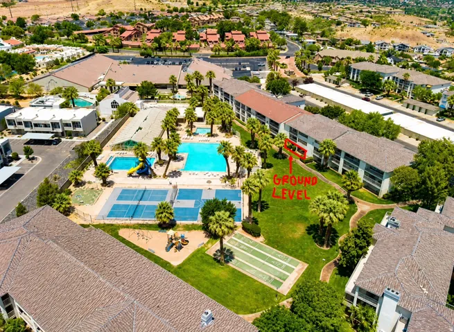 Community amenities featuring multiple swimming pools, tennis courts, and bocce ball courts surrounded by mature palm trees and green spaces