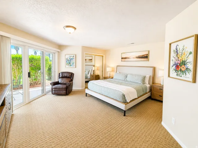 Expansive bedroom featuring patterned carpeting and neutral wall tones