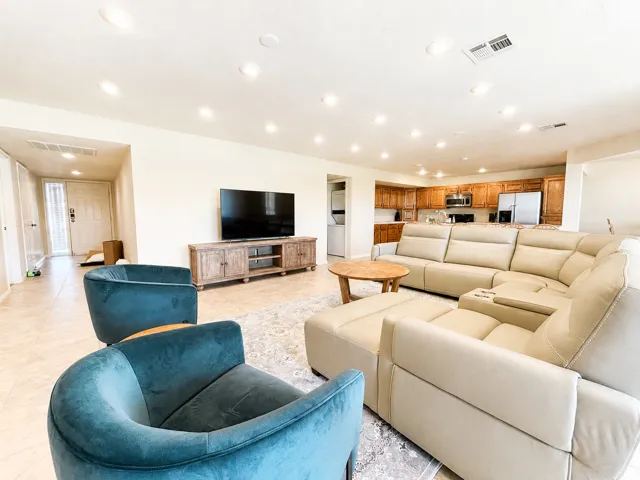 Open-concept living area with recessed lighting, tile flooring, and light-toned walls