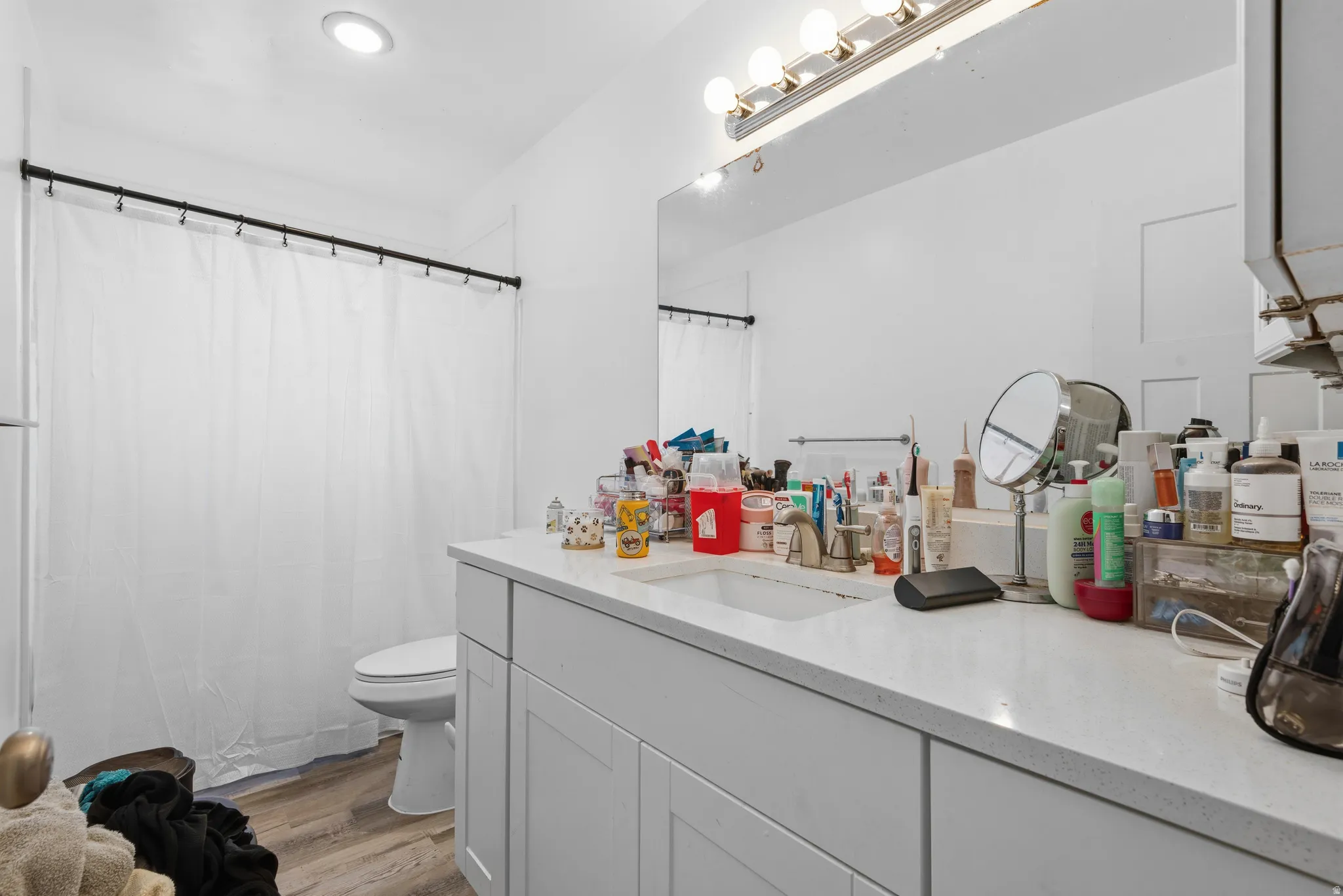 White vanity featuring a single integrated sink, light-colored countertop, and cabinet storage