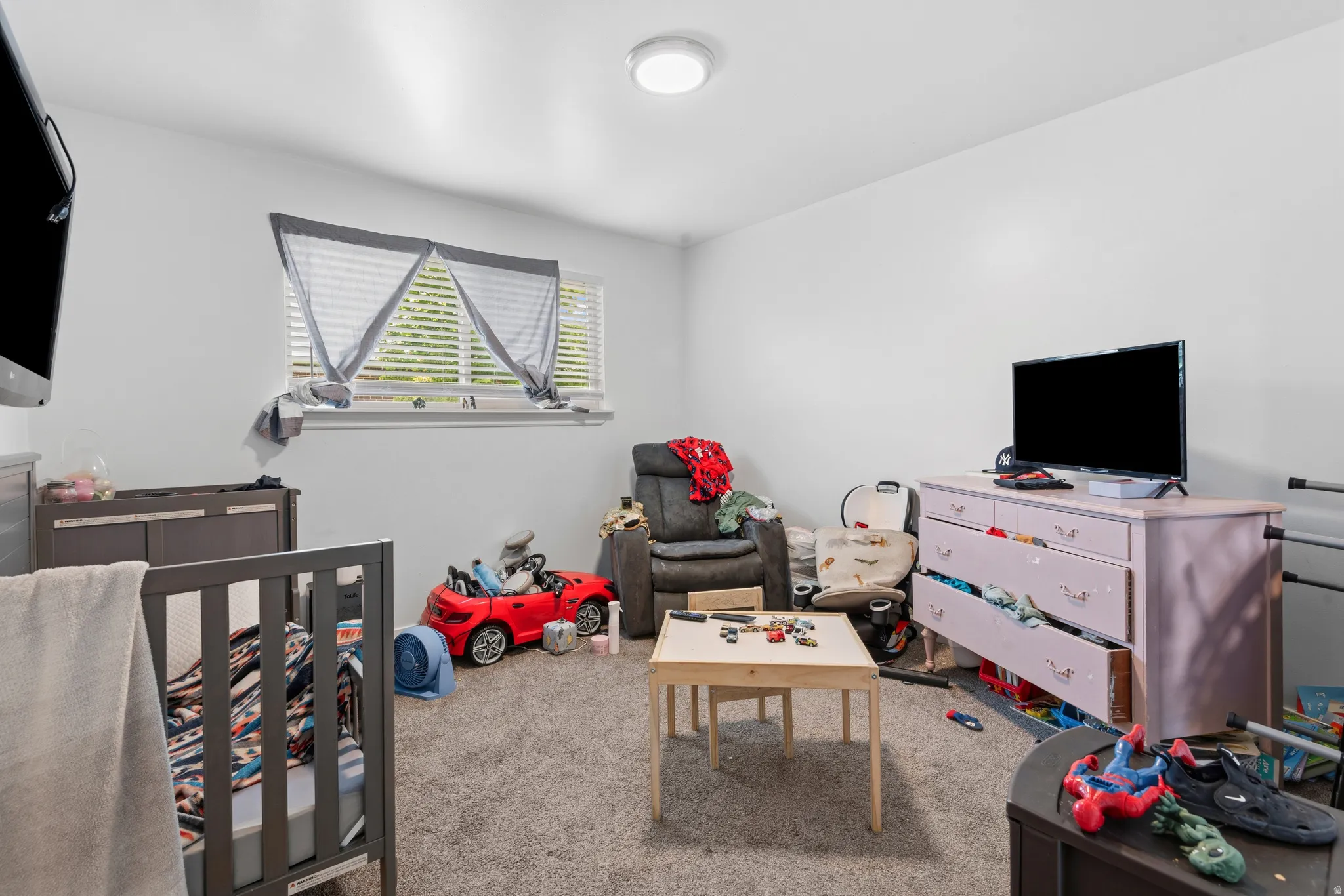 Carpeted room with a ceiling-mounted light fixture