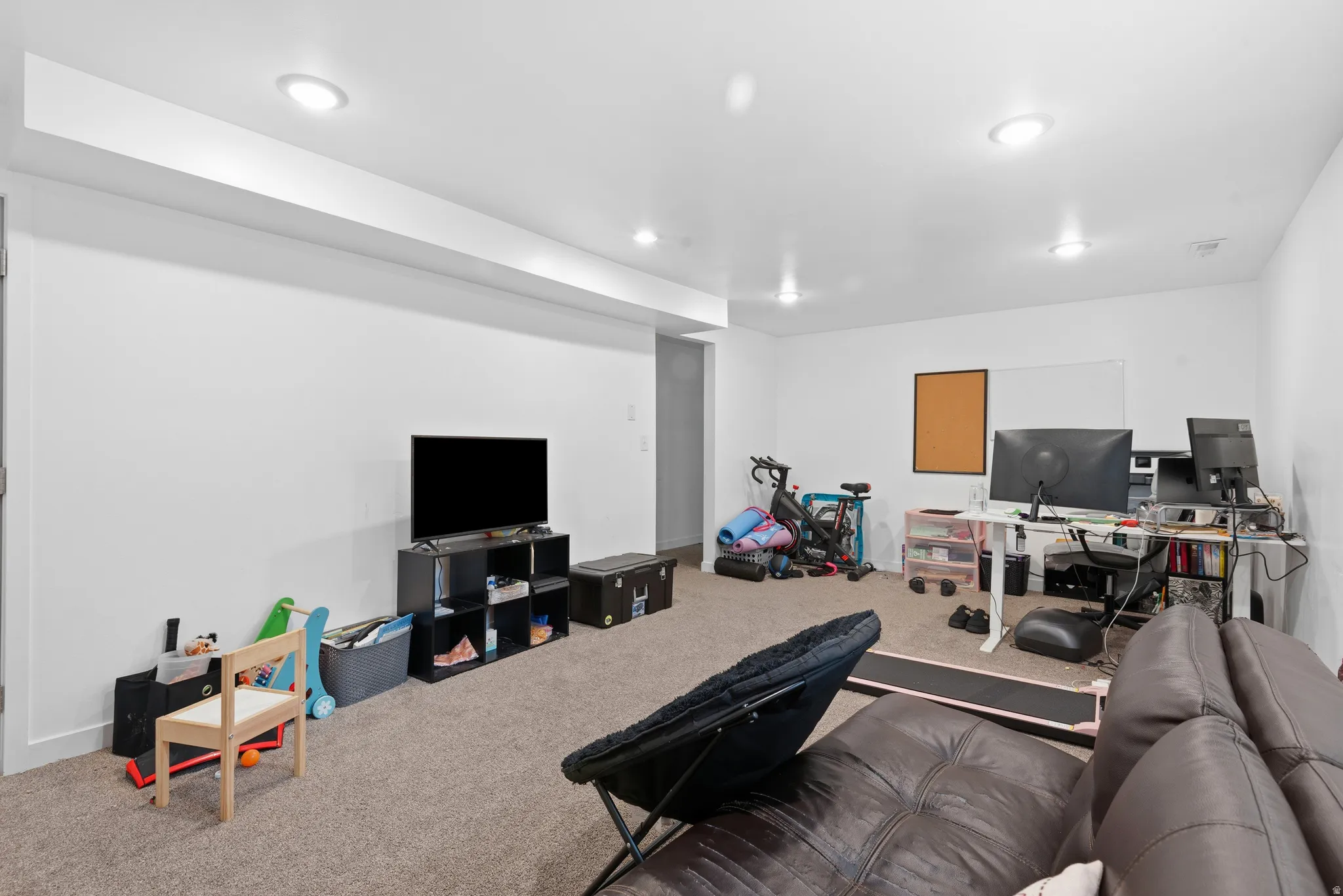 Spacious room featuring neutral carpet flooring and recessed ceiling lighting