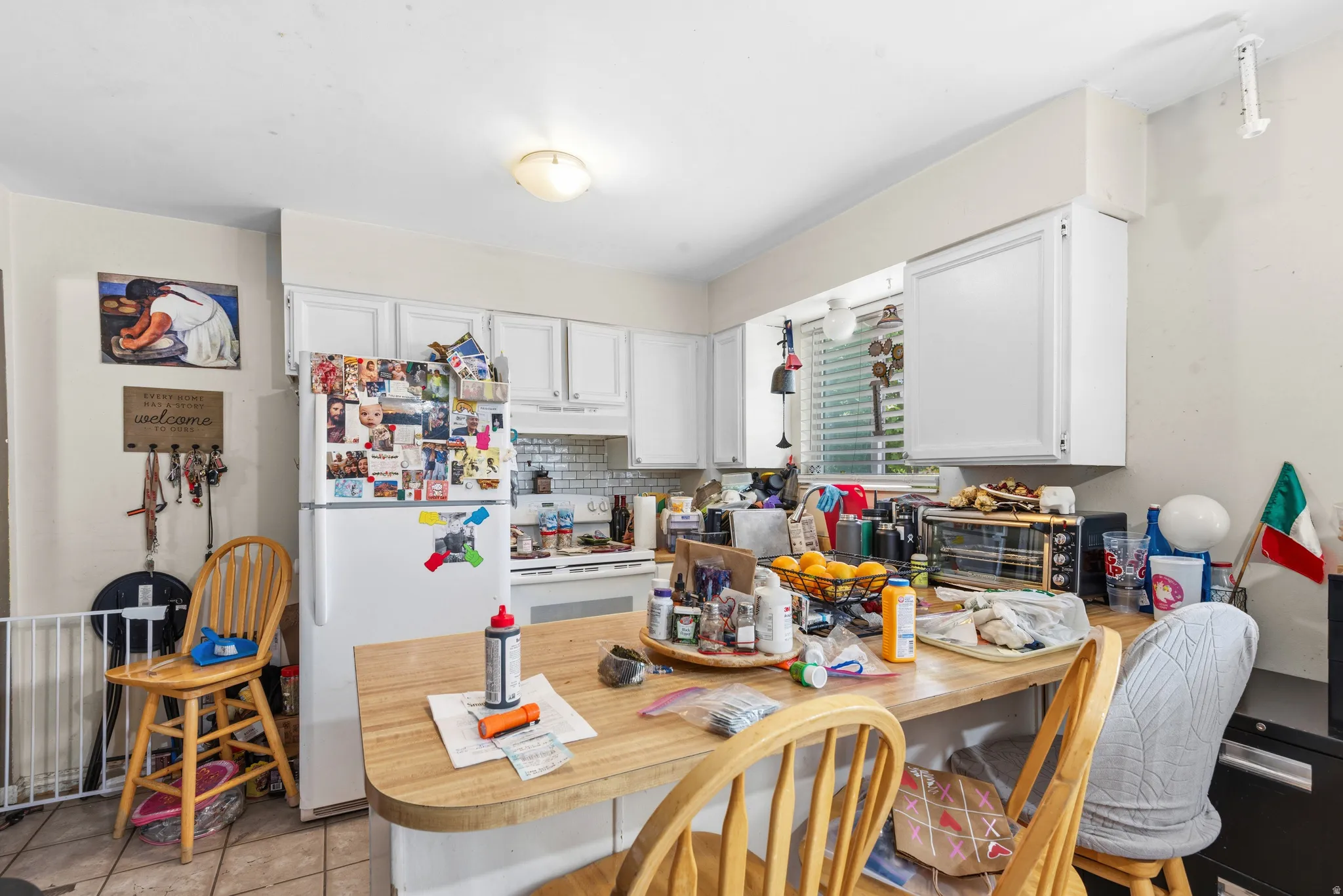 Kitchen featuring white cabinetry, a tiled backsplash, and an integrated wood-finish countertop with seating