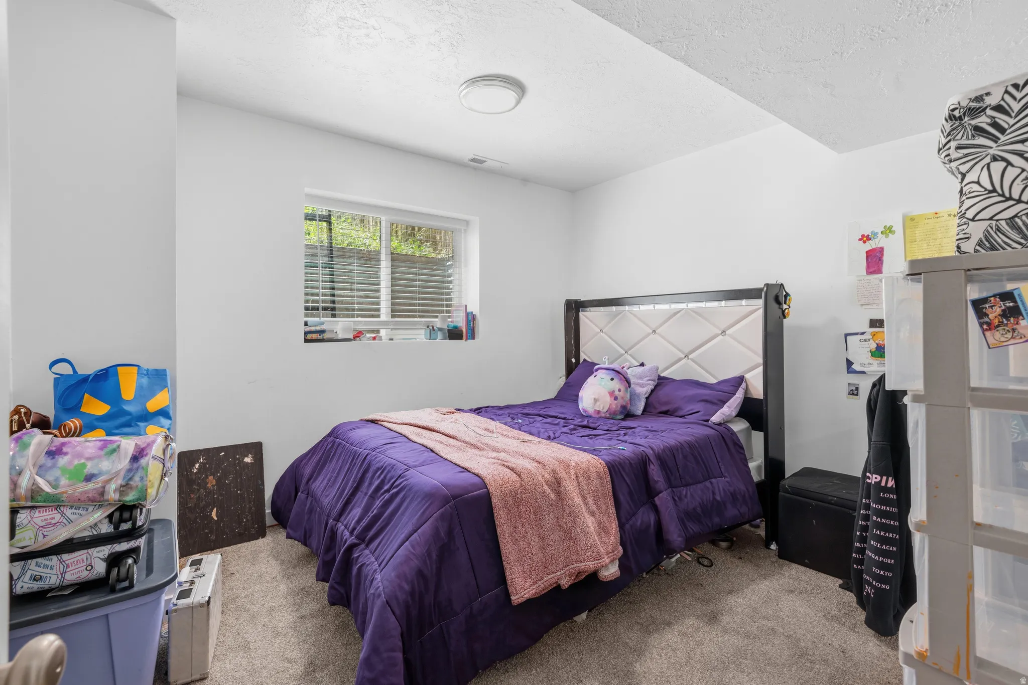 Bedroom featuring neutral carpeting and a window with blinds