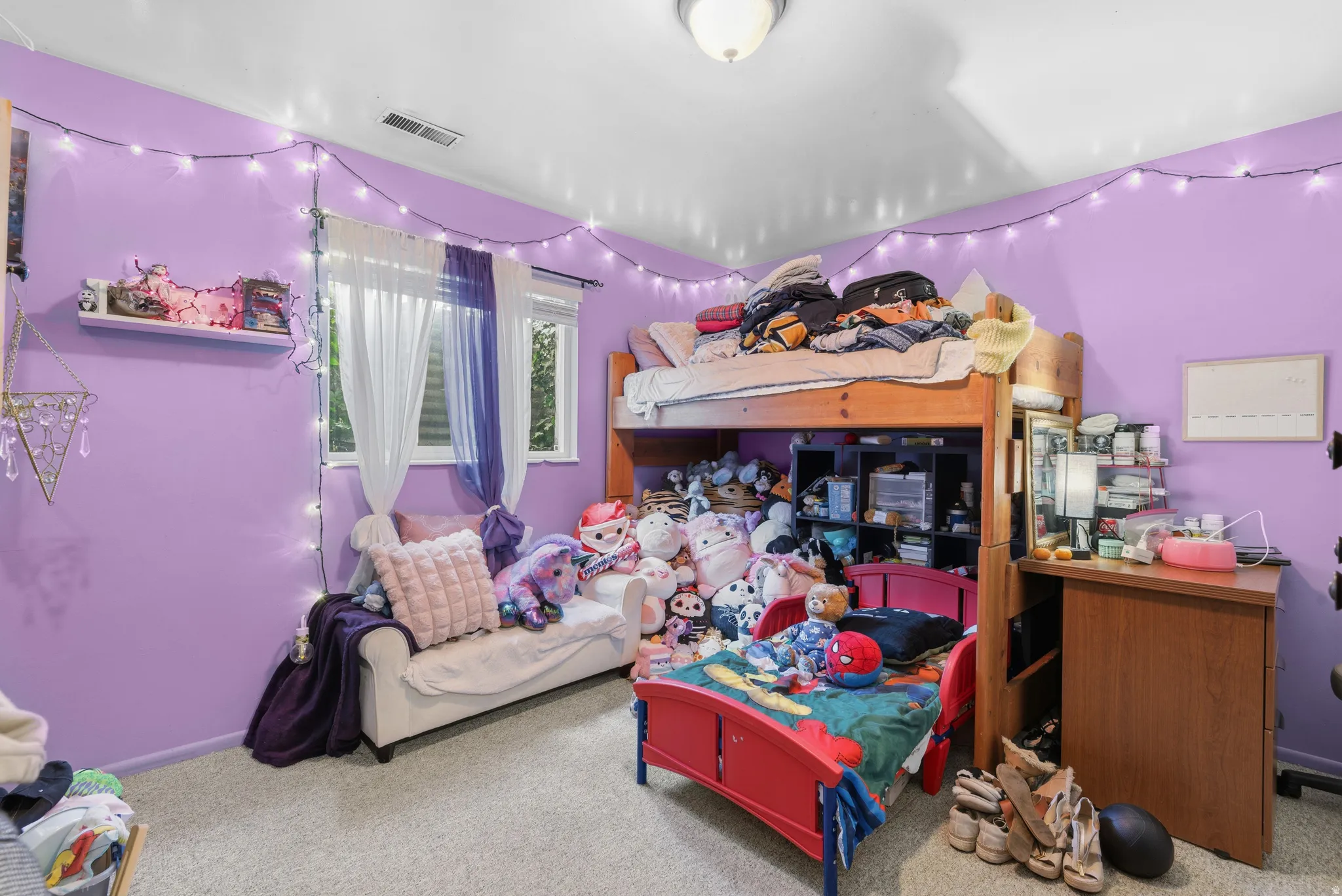 Room featuring light purple walls, a ceiling-mounted light fixture, and light-colored carpeting