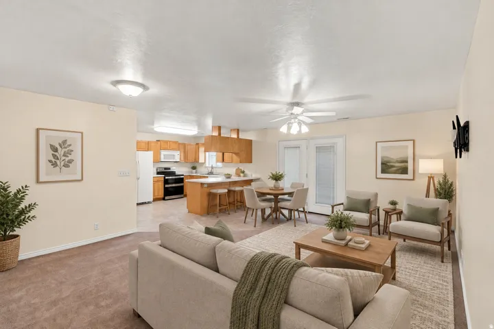 Open-concept living area with carpet flooring, a ceiling fan, and French doors