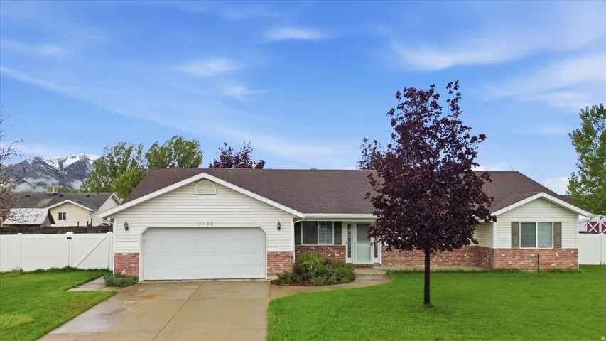 Ranch-style residence featuring a white vinyl exterior and brick accents