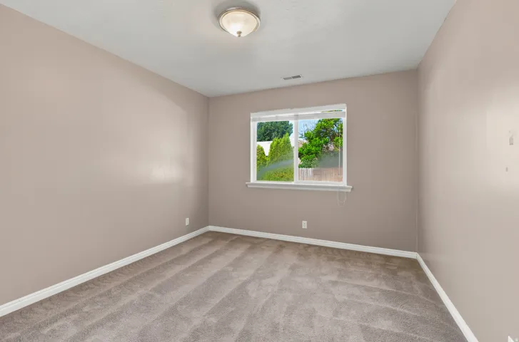 Neutral-toned walls and plush carpet flooring complement a white trim throughout this room