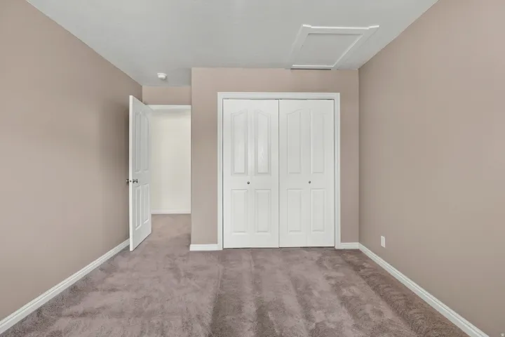 Carpeted room with neutral wall tones and white baseboards