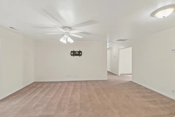 Spacious room featuring neutral carpeting and light-toned walls