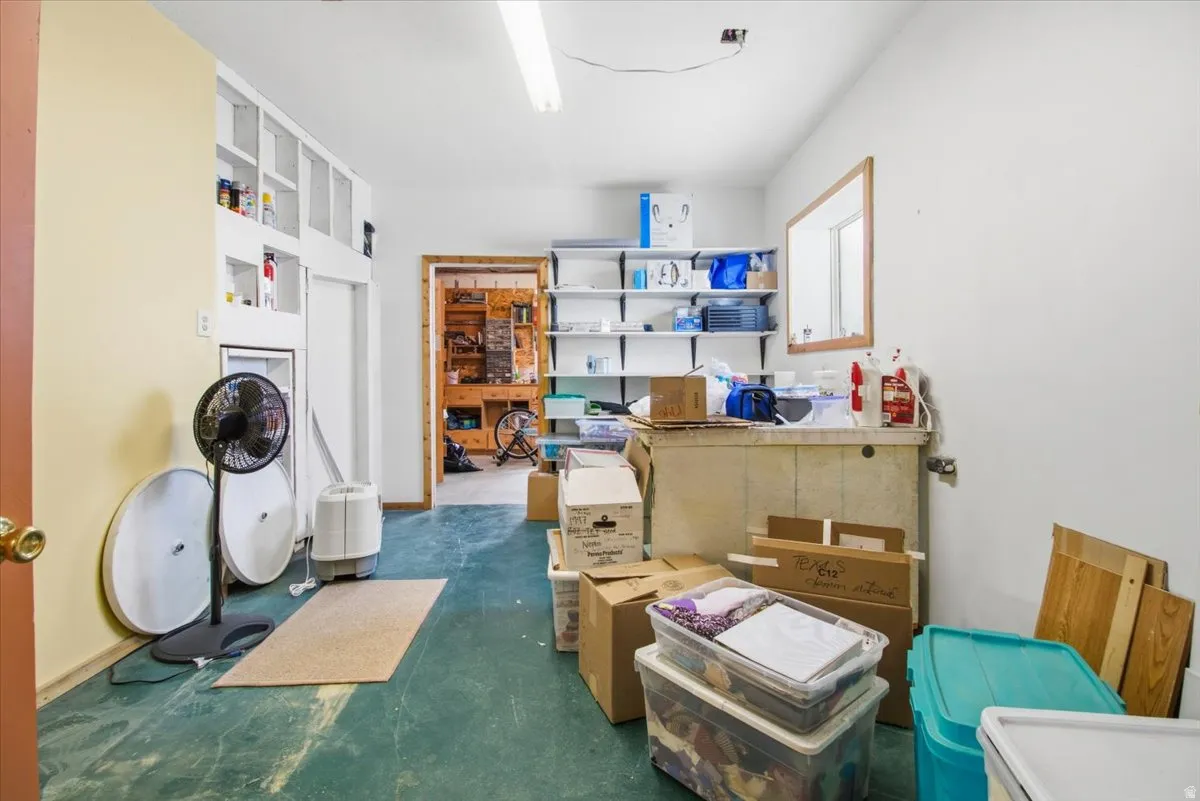 Utility room featuring built-in shelving, durable flooring, and a work surface