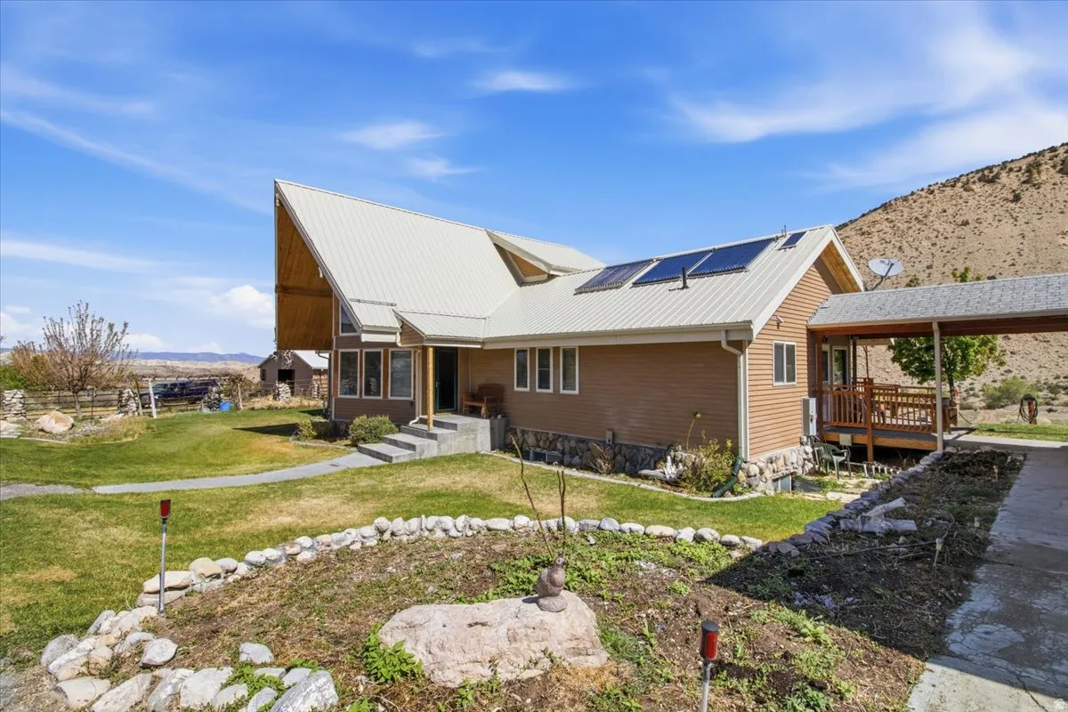 Contemporary residence featuring a metal roof, solar panels, and a stone foundation