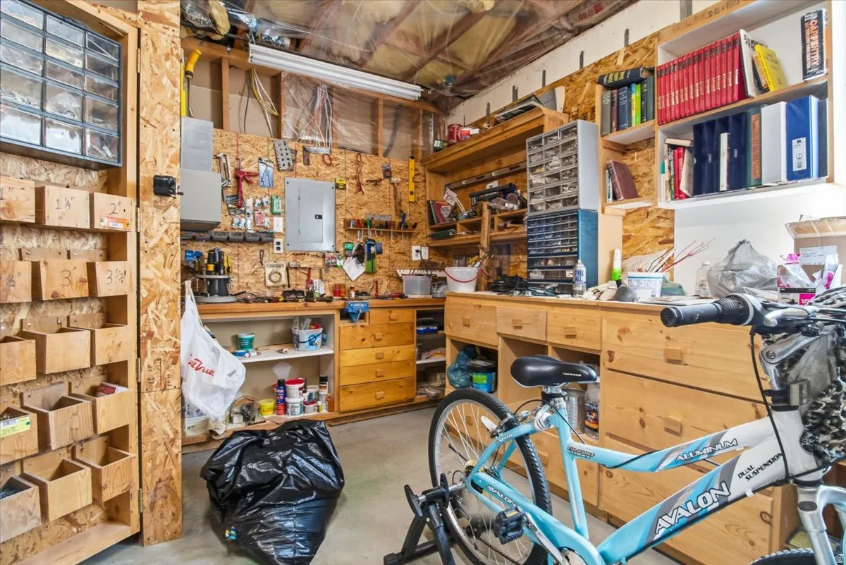 Dedicated workspace featuring wood-finish workbenches, built-in storage drawers, and wall-mounted shelving