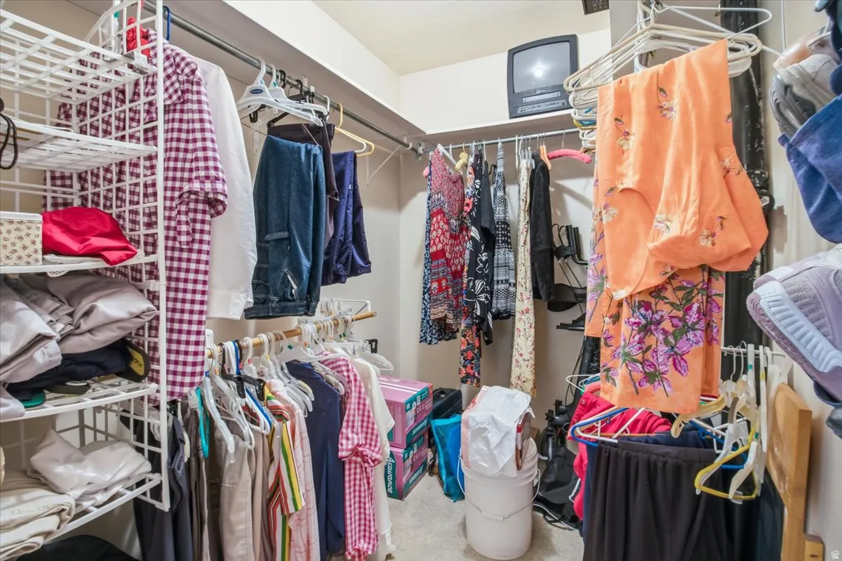 Walk-in closet featuring built-in wire shelving, multiple hanging rods, and neutral-toned walls