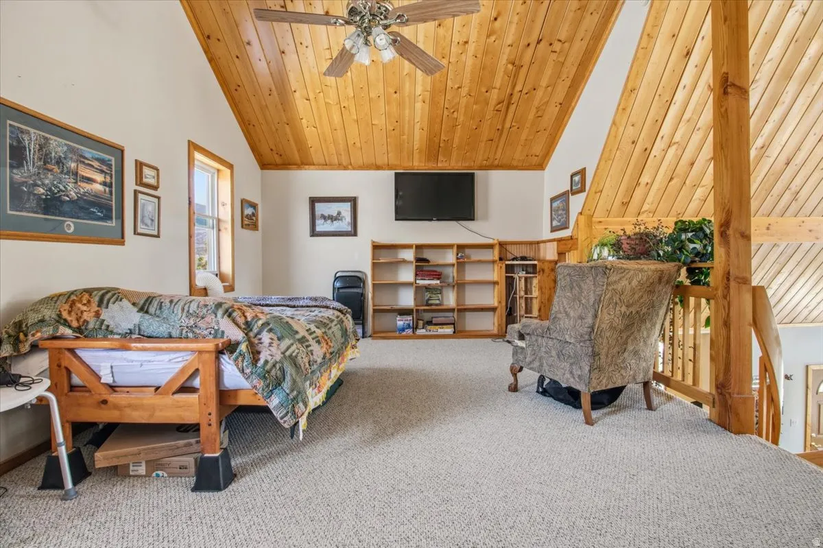 Vaulted wood-paneled ceiling with a central ceiling fan