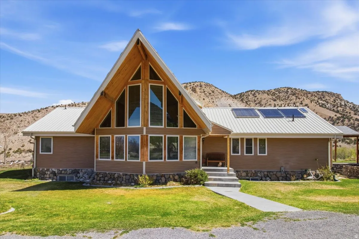 A-frame architectural style featuring a striking window wall, wood-finish gables, and a metal roof