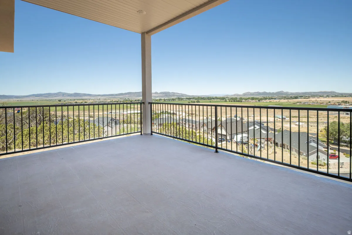 Expansive outdoor deck featuring a covered ceiling with recessed lighting, durable concrete flooring, and black metal railing