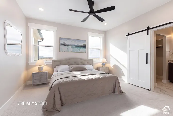 Recessed lighting, ceiling fan, carpeted flooring, and a white barn door with black hardware