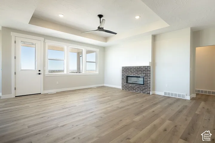 Wood-finish flooring, recessed lighting, and a tray ceiling