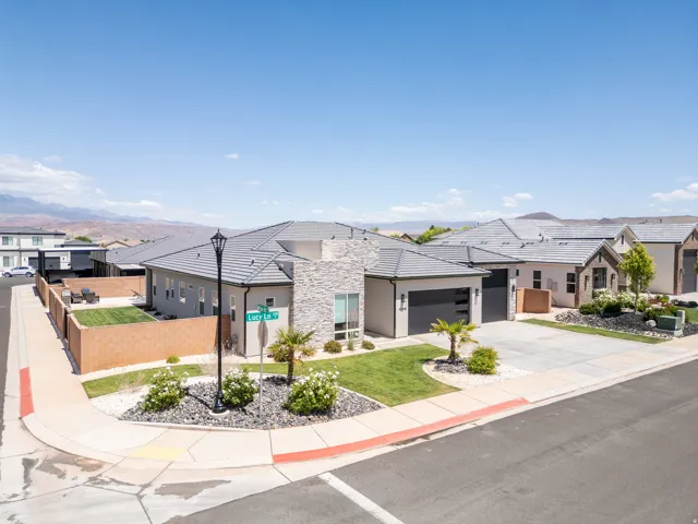 Contemporary residence featuring a stone and stucco exterior, a two-car garage with modern doors, and a tiled roof