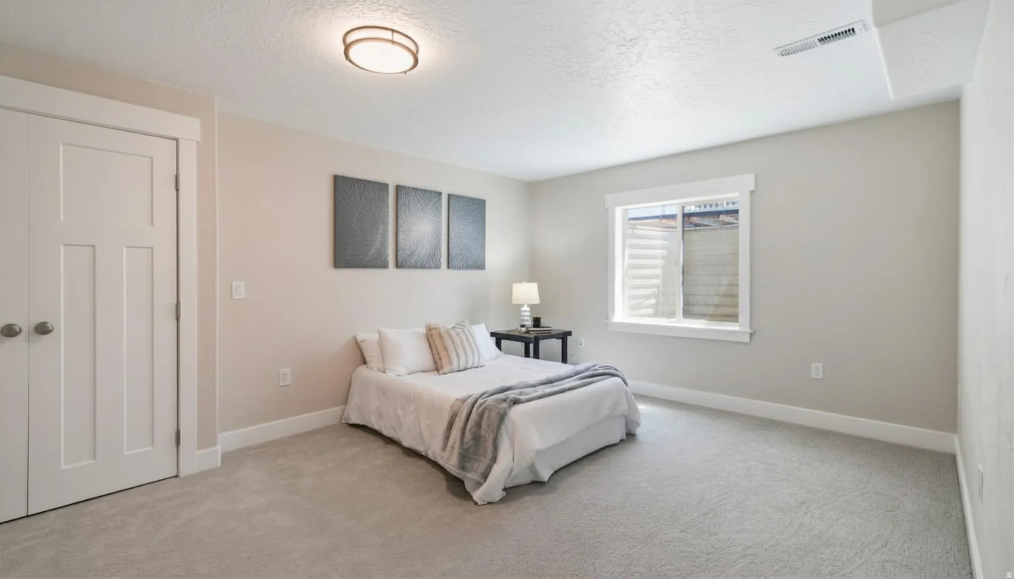 Neutral toned room featuring a flush mount ceiling light, light gray carpeting, and white baseboards