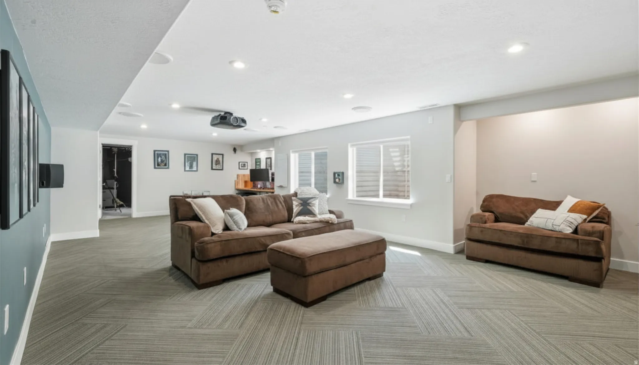 Spacious lower-level area featuring recessed lighting and ceiling-mounted projector