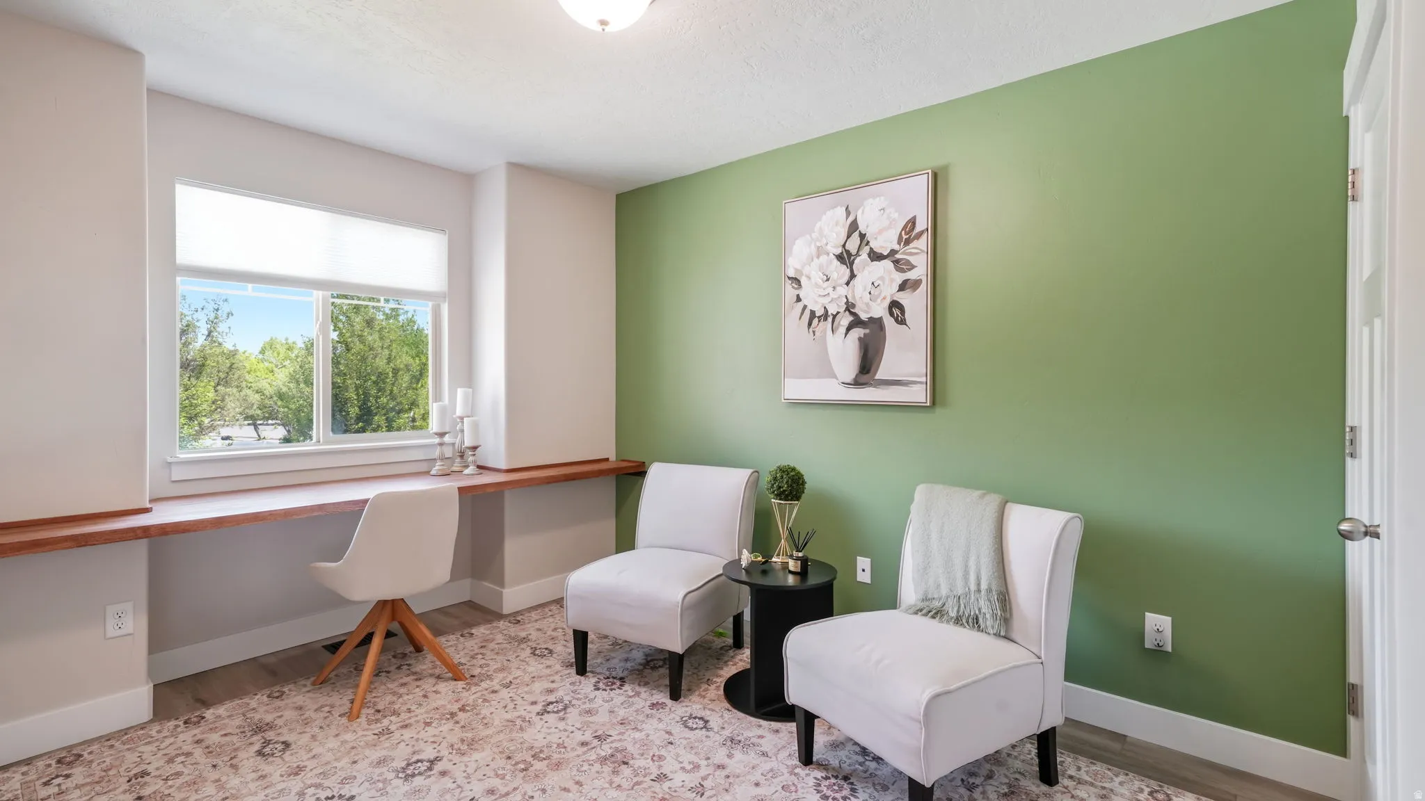Dedicated workspace featuring a built-in wood-finish desk, large window, and closet