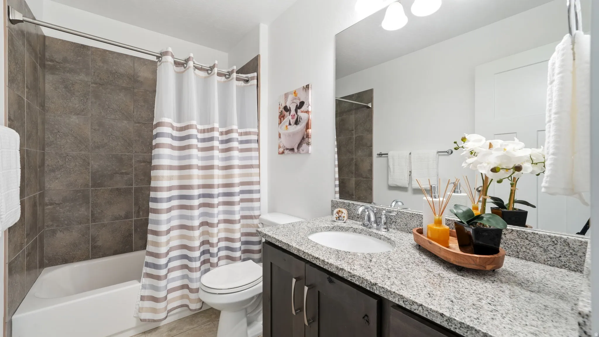 Full bathroom featuring a bathtub with tile surround, a vanity with drop-in sink and granite countertop