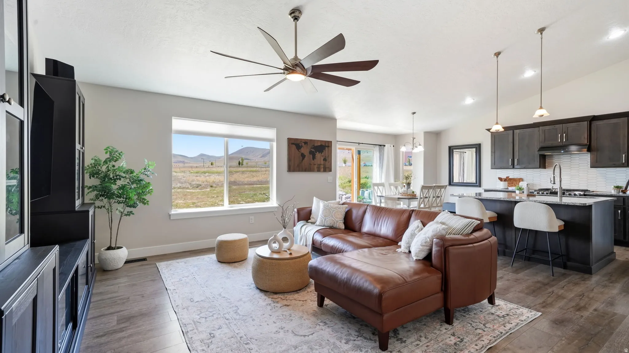 Open-concept living area featuring wood-finish flooring, a contemporary ceiling fan, and recessed lighting