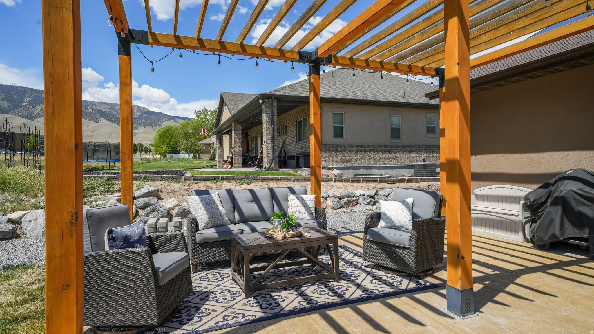 Spacious outdoor patio featuring a wood pergola with direct access to the main residence