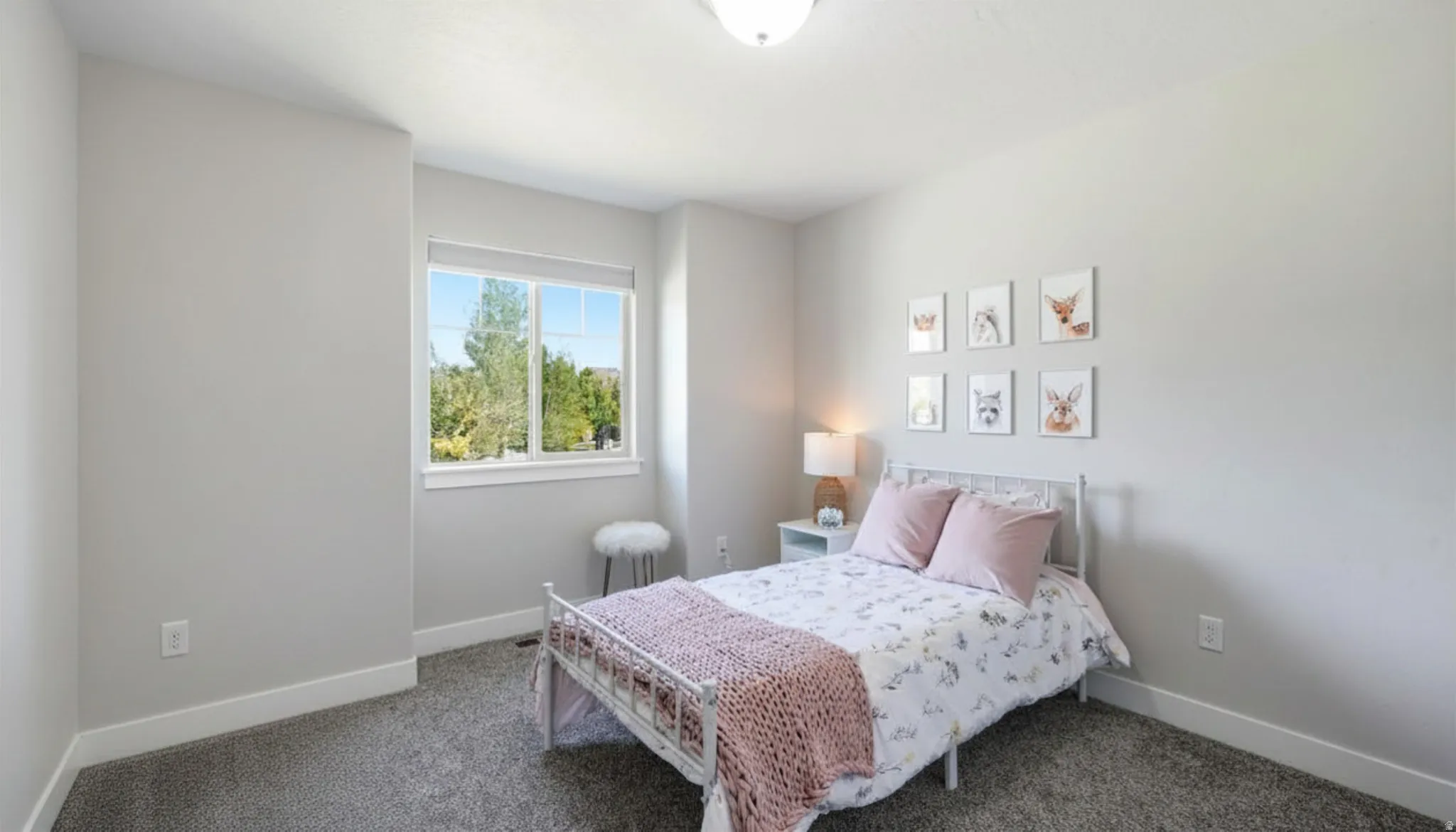 Carpeted bedroom featuring a large window with white trim, and white baseboards