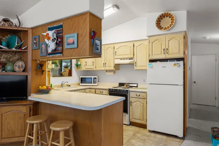 Kitchen featuring wood-finish cabinetry, a U-shaped countertop, and an integrated breakfast bar