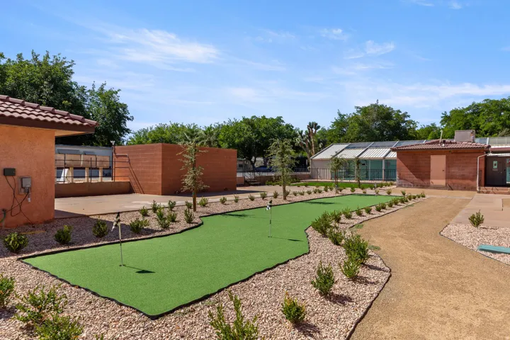Outdoor putting green surrounded by gravel landscaping and low-maintenance plantings